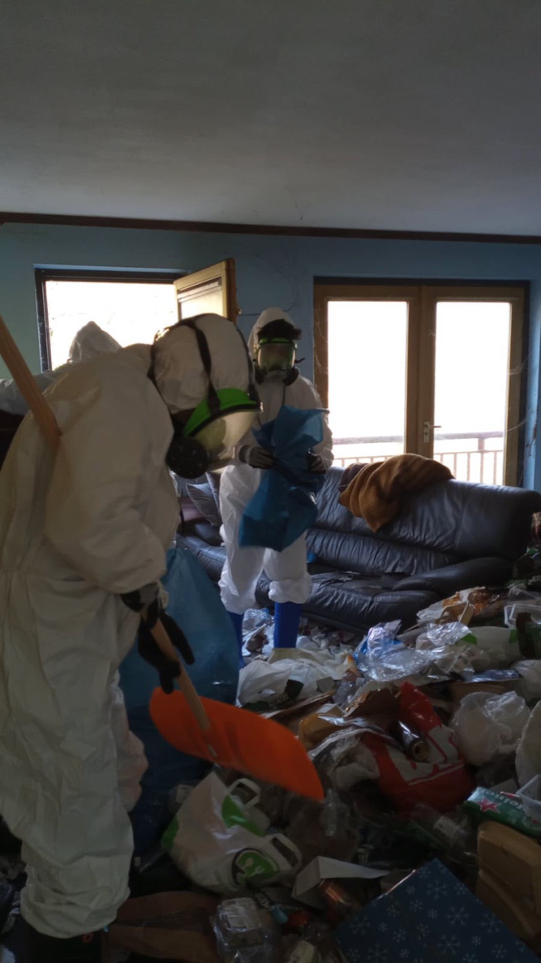 Team in beschermende kleding tijdens een ontruiming en dieptereiniging